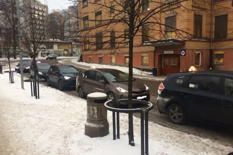 En parkeringsplass med biler og en bygning i bakgrunnen