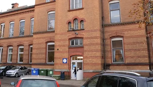 En murbygning med biler parkert foran den
