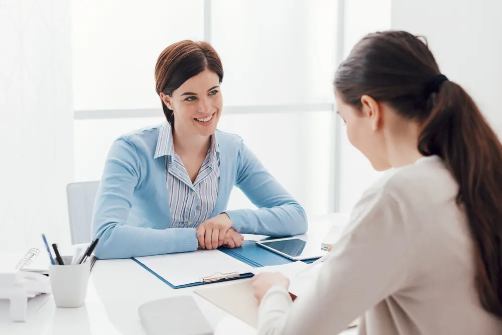 A woman and a woman looking at a paper