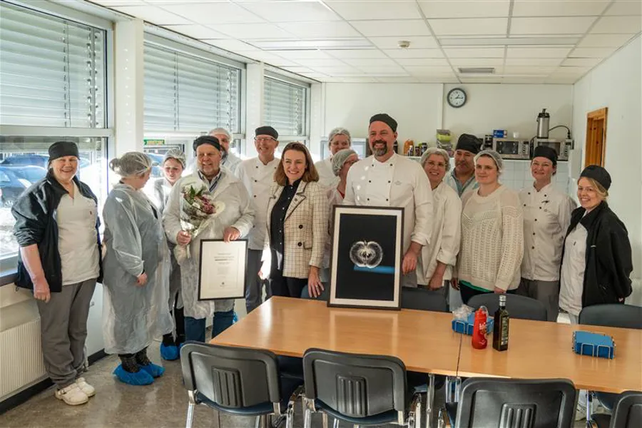 En gruppe mennesker i hvite laboratoriefrakker som står i et rom
