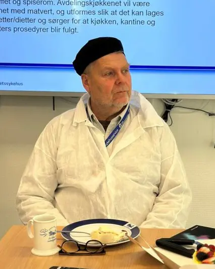 En mann som sitter ved et bord