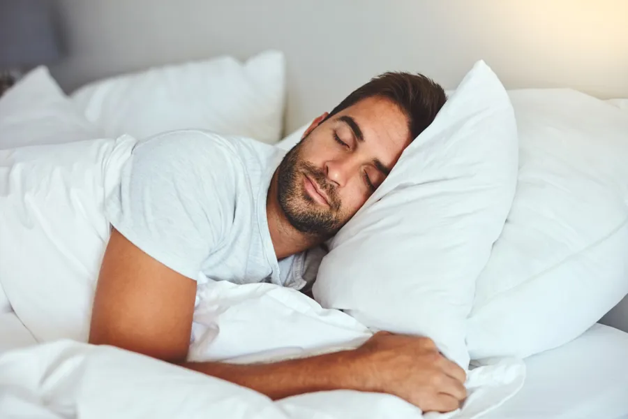 En mann som sover på en seng