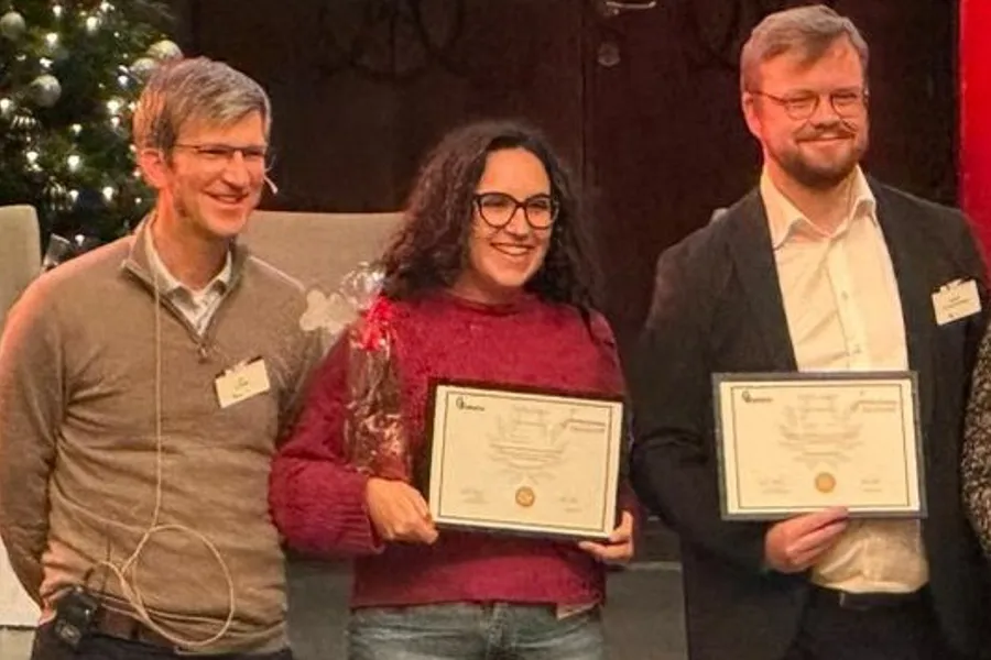 Giulia in the middle of two other participants, receives her Diploma.