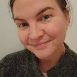 En kvinne som smiler til kameraet