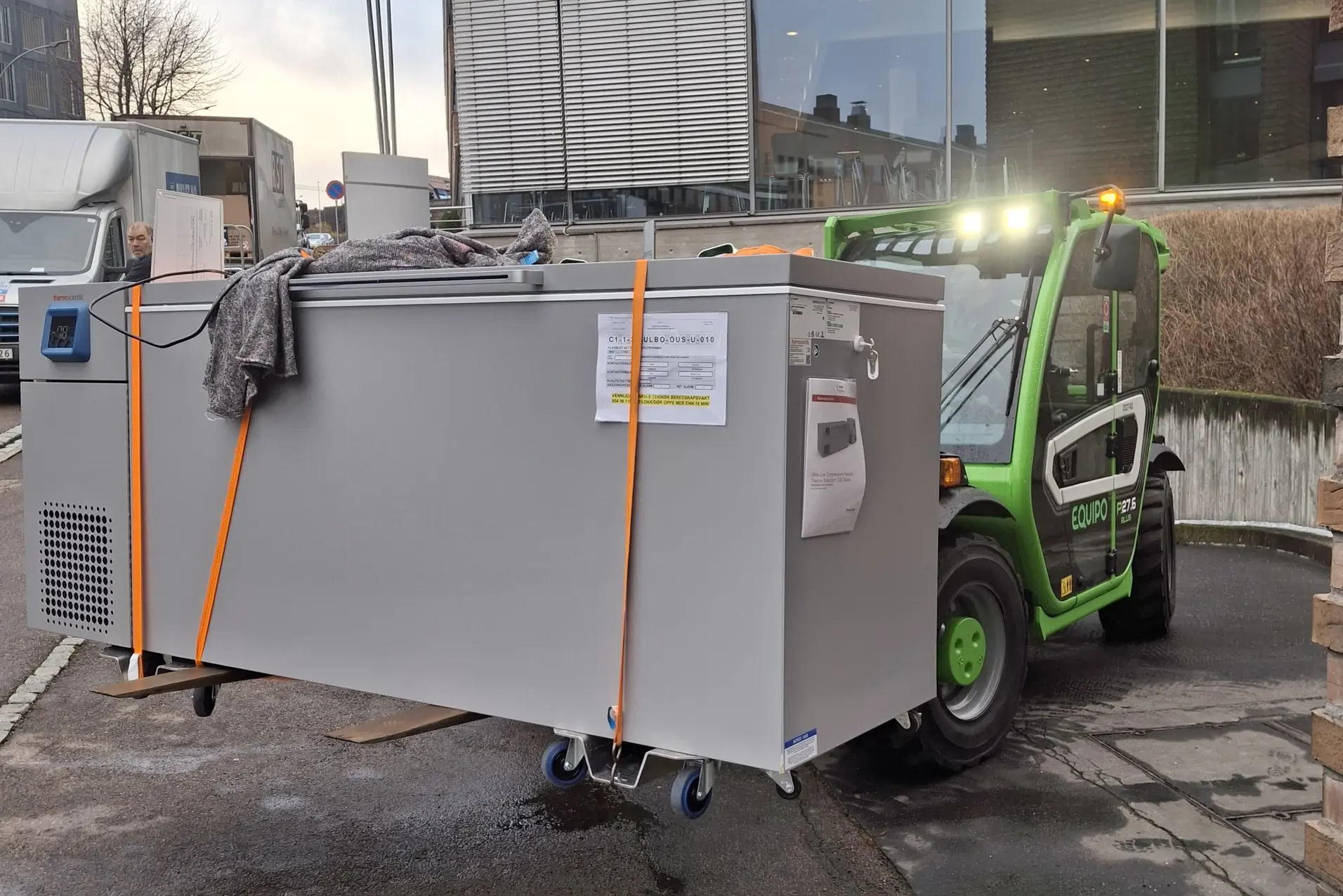 Bildet viser en truck som løfter en fryser