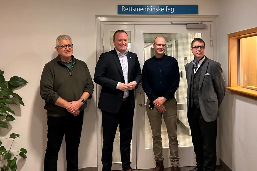 En gruppe menn som står foran en dør