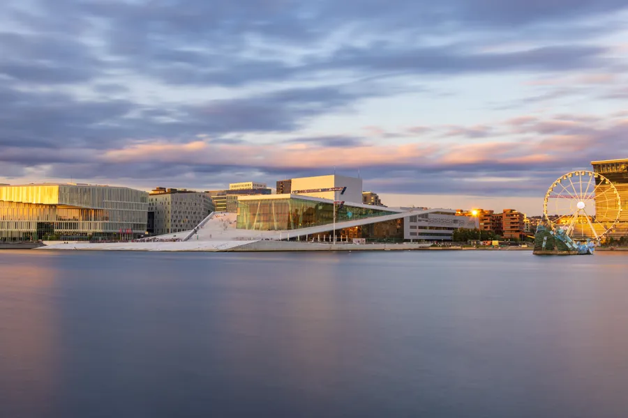 oversiktsbilde av bjørvika med operaen, deichman og munch i solnedgang