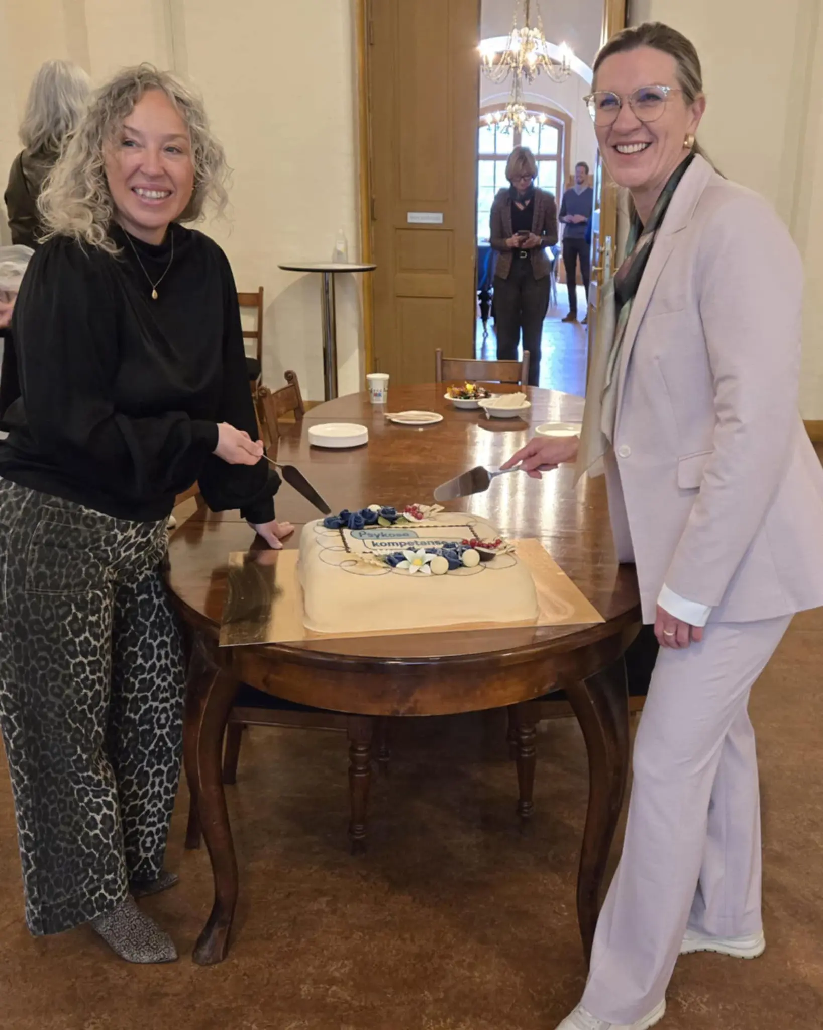 Et par kvinner som skjærer en kake