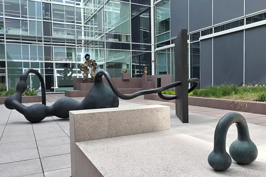 Utsnitt av skulpturhagen med skulpturer og fargede betongelementer.