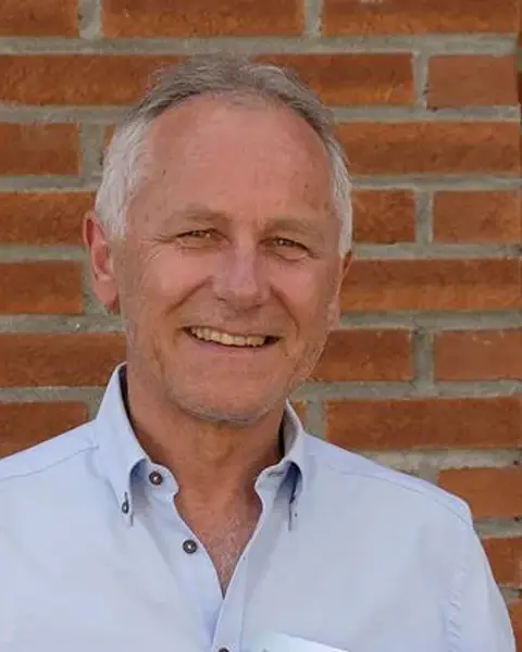 En mann som smiler til kameraet