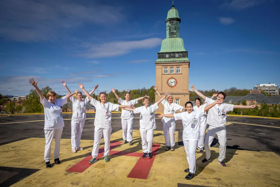 En gruppe mennesker som poserer for et bilde foran et tårn